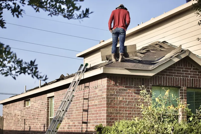 Professional roofer working on a residential roof in Summit East